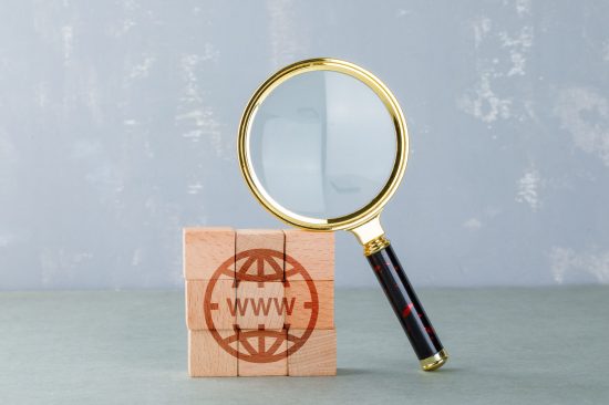 conceptual-internet-search-with-wooden-blocks-with-internet-icon-magnifying-glass-side-view (1)